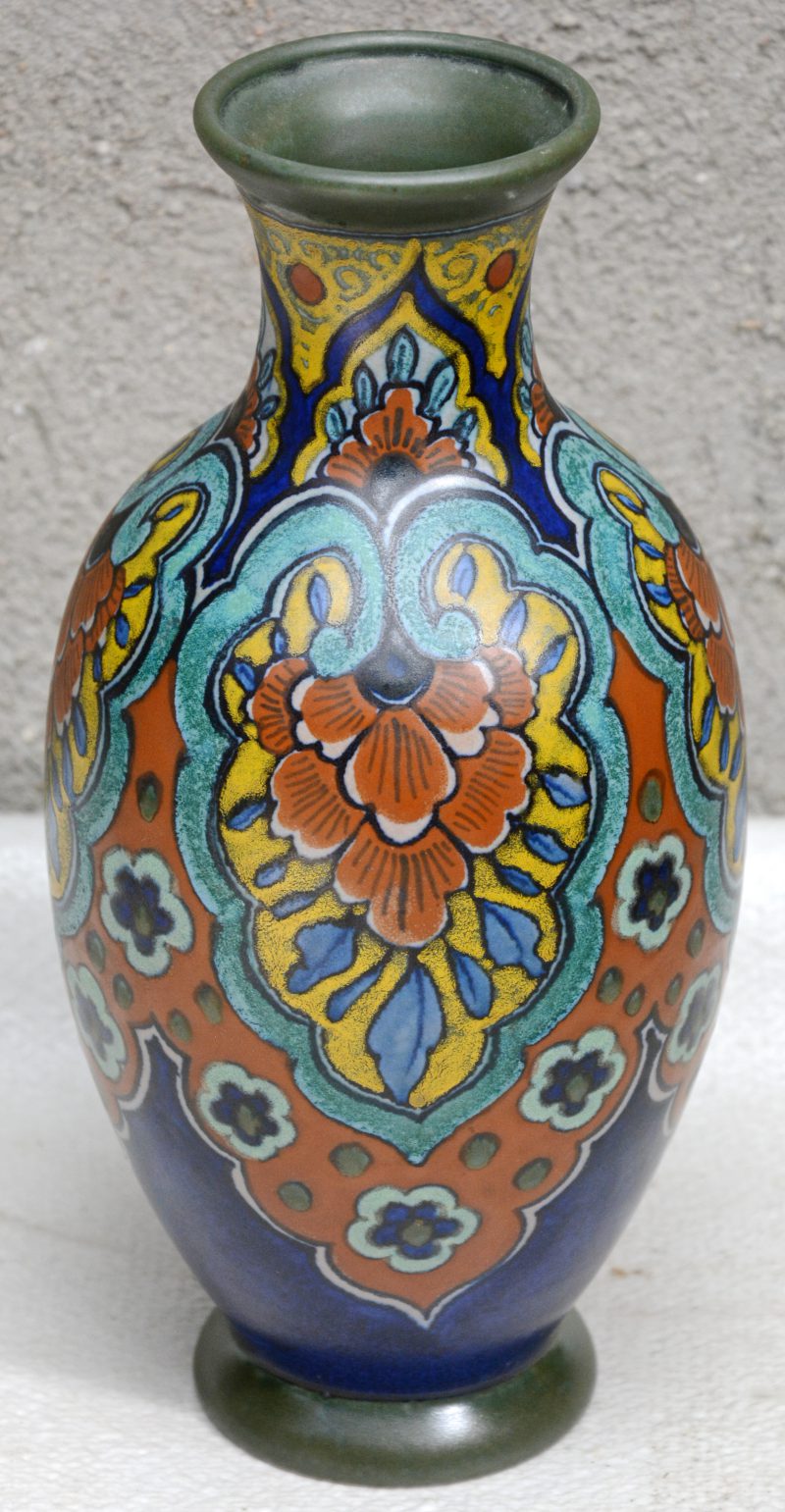Een vaas van Gouds plateel met meerkleurig decor ‘Mabel’. Onderaan gemerkt. Jaarmerk 1920.