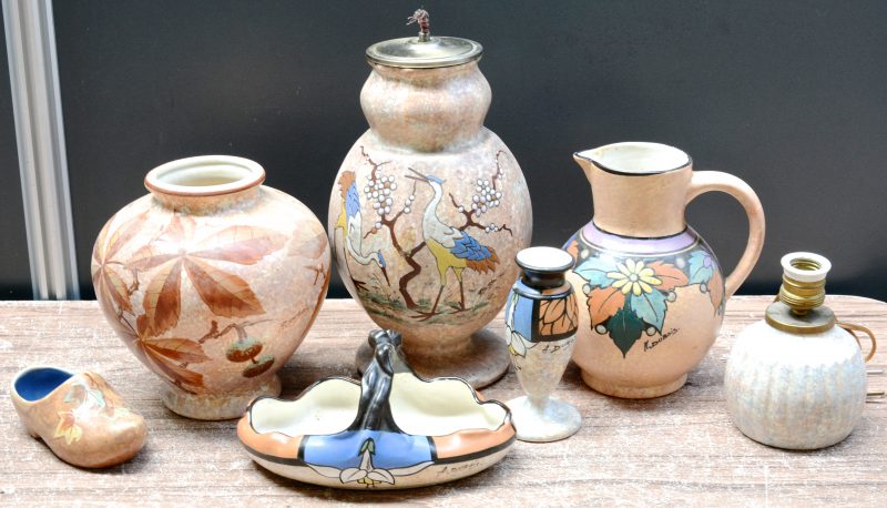 Een lot meerkleurig aardewerk met decors van Antoine Dubois, bestaande uit twee lampvoeten, een bole vaas, een vaasje op voet, een mandje, een bolle schenkkan en een klompje. Gemerkt.
