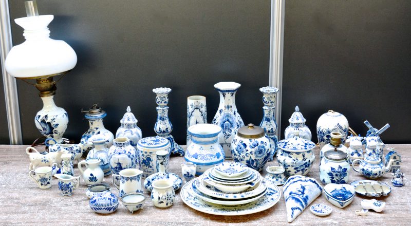 Een zeer gevarieerd lot blauw en wit aardwerk in Delftse stijl, bestaande uit vazen, kandelaars, borden, schotels, diertjes, huisjes, enz. diverse merken.