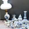 Een zeer gevarieerd lot blauw en wit aardwerk in Delftse stijl, bestaande uit vazen, kandelaars, borden, schotels, diertjes, huisjes, enz. diverse merken.