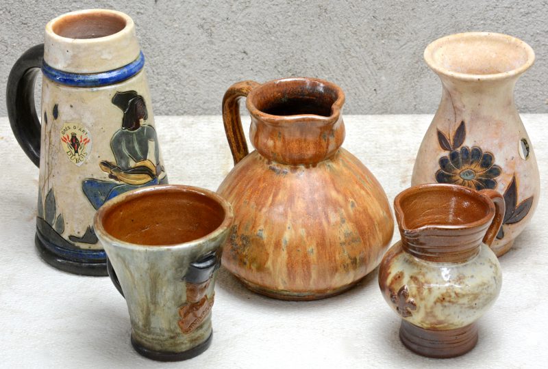 Een lot Waals steengoed, bestaande uit een pul met meerkleurig reliëfdecor, een beker met ‘Waterloo’, een vaas met ‘Orval’ en twee schenkkannetjes. Onderaan gemerkt.