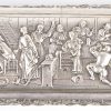 Een gedreven zilveren doos met barokke versiering. Op het deksel een scène naar David Teniers in reliëf. Hollandse keuren, tweede gehalte. Makersmerk EMB. Letsels aan twee pootjes.