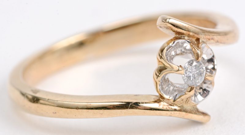 Een 14 karaats geel gouden bloemvormige ring bezet met een briljantje.