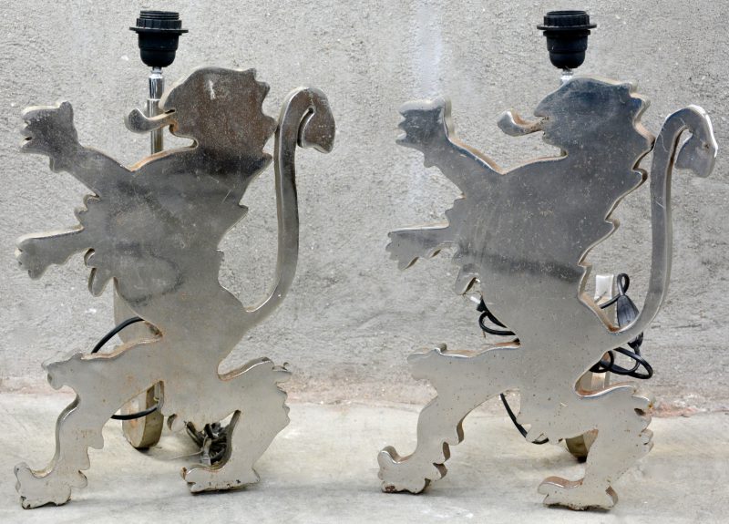 Twee metalen vuurbokken in de vorm van heraldische leeuwen, gemonteerd als lampen.