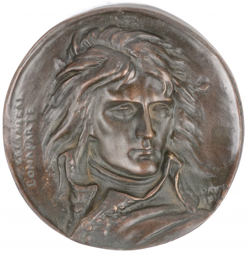 Een bronzen plaquette met een beeltenis van Napoleon in reliëf.