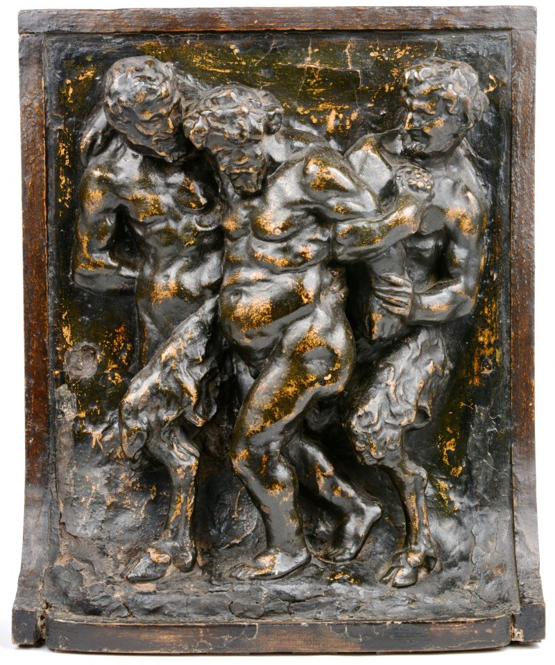 Een houten reliëf met een voorstelling van Bacchus, ondersteund door twee saters.
