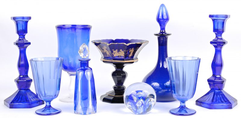 Een lot blauw glas en kristal, bestaande uit een paar kandelaars, een karaf, een vaas op voet, een coupe op voet, twee glazen, een klein karafje en een presse-papier.