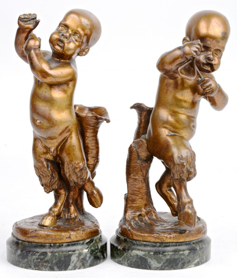 “Musicerende saters”. Een paar bronzen beeldjes op marmeren sokkel. Fluit manco.