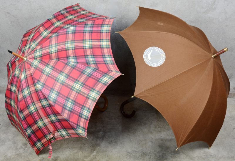 Twee verschillende paraplu’s met houten handvat.