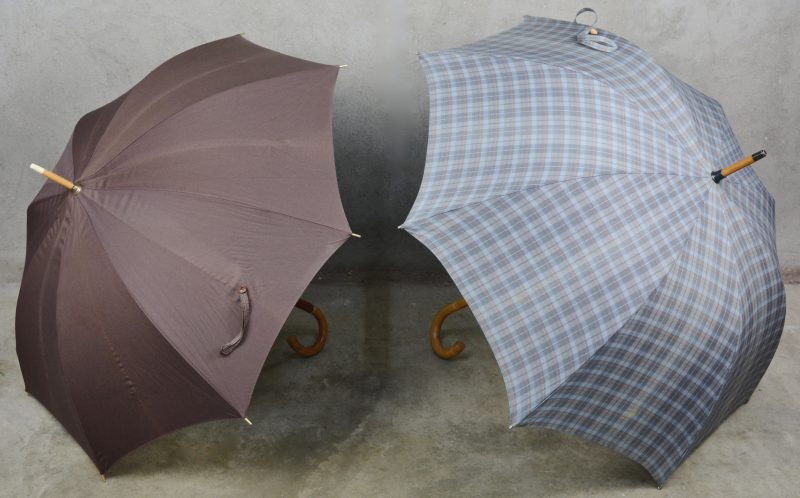 Twee verschillende paraplu’s met houten handvat.