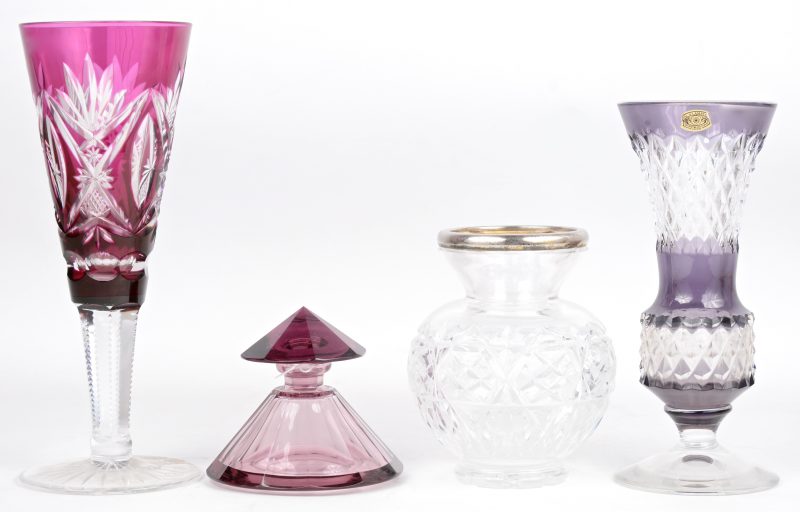 Een lot geslepen kristal, bestaande uit een mauve e,n een paarse vaas op voet, een mauve inktpot en een kleurloze vaas met 835‰ zilveren montuur.