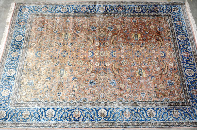 Handgeknoopt wollen tapijt. Centraal islimi motief met herati bloemen op roestbruine fond. Brede herati boord  met blauwe fond.