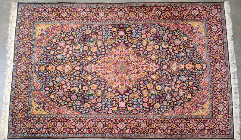 Handgeknoopt wollen karpet met zijden details. Centraal medaillon, het geheel bezaaid met bloemen.