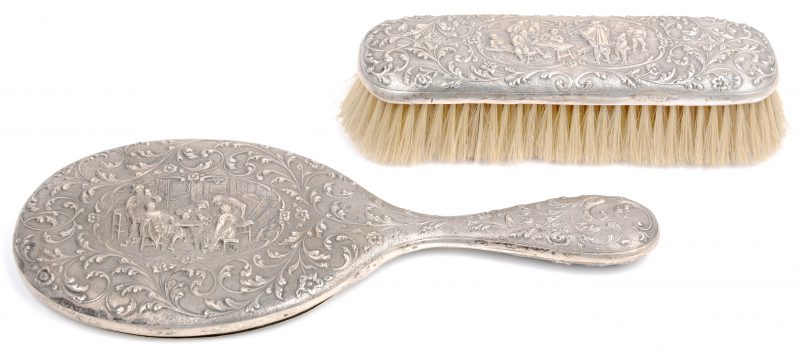 Een decoratieve zilveren spiegel en borstel met Nederlandse keuren tweede gehalte.