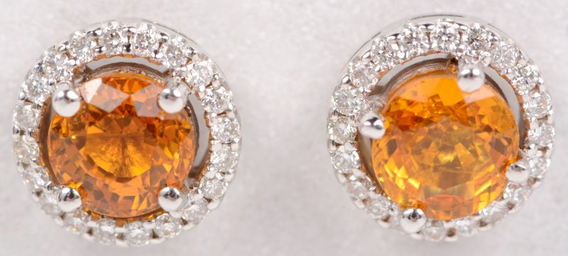 Een paar 18 karaats wit gouden oorbellen bezet met diamanten met een gezamenlijk gewicht van ± 0,38 ct. en twee gele saffieren met een gezamenlijk gewicht van ± 1,10 ct.