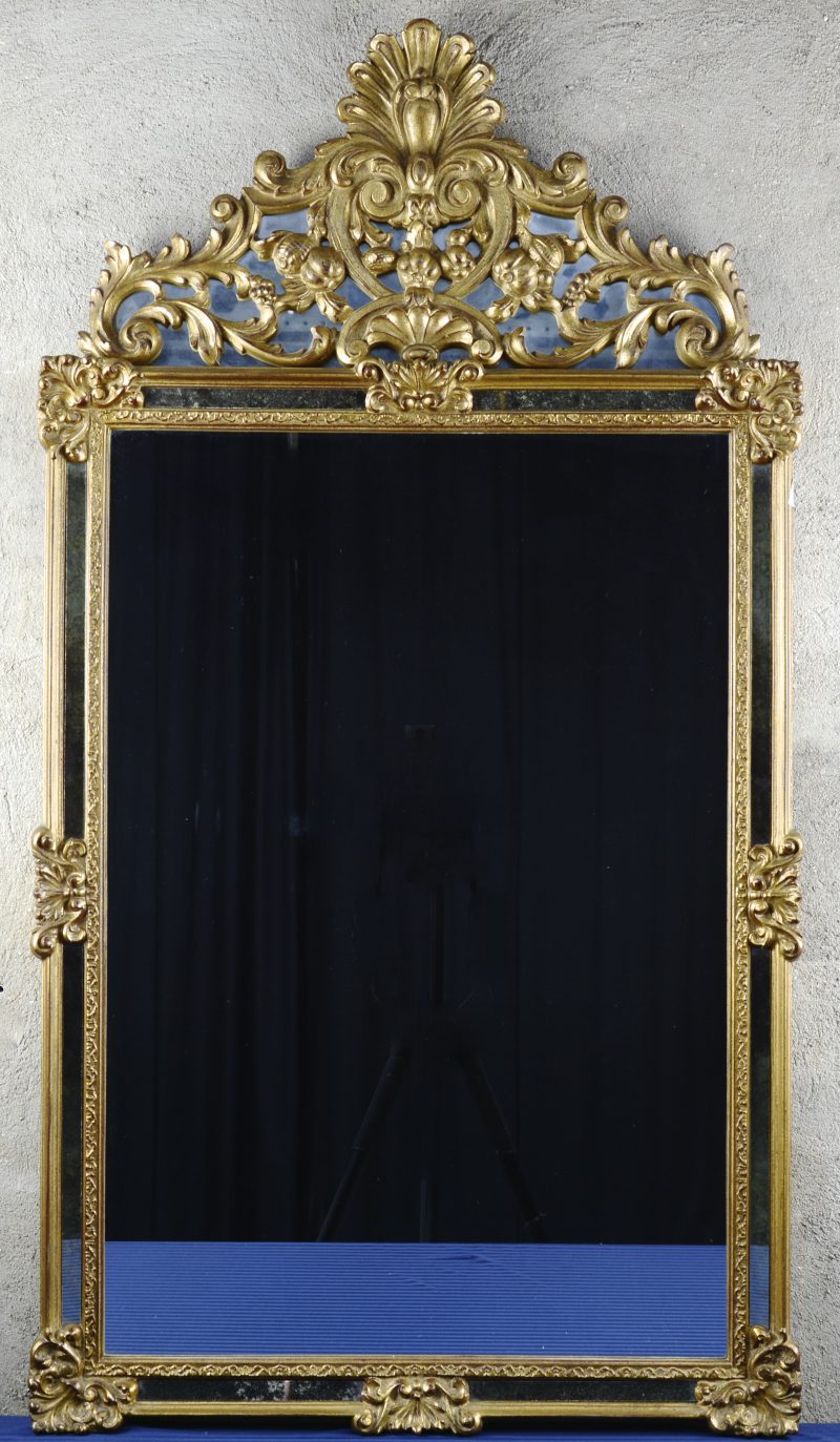 Een goudgepatineerd houten spiegel in barokke stijl.