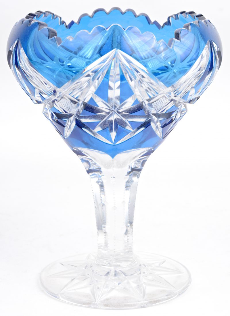 Een geslepen kristallen coupe, blauw in de massa met gekartelde rand.