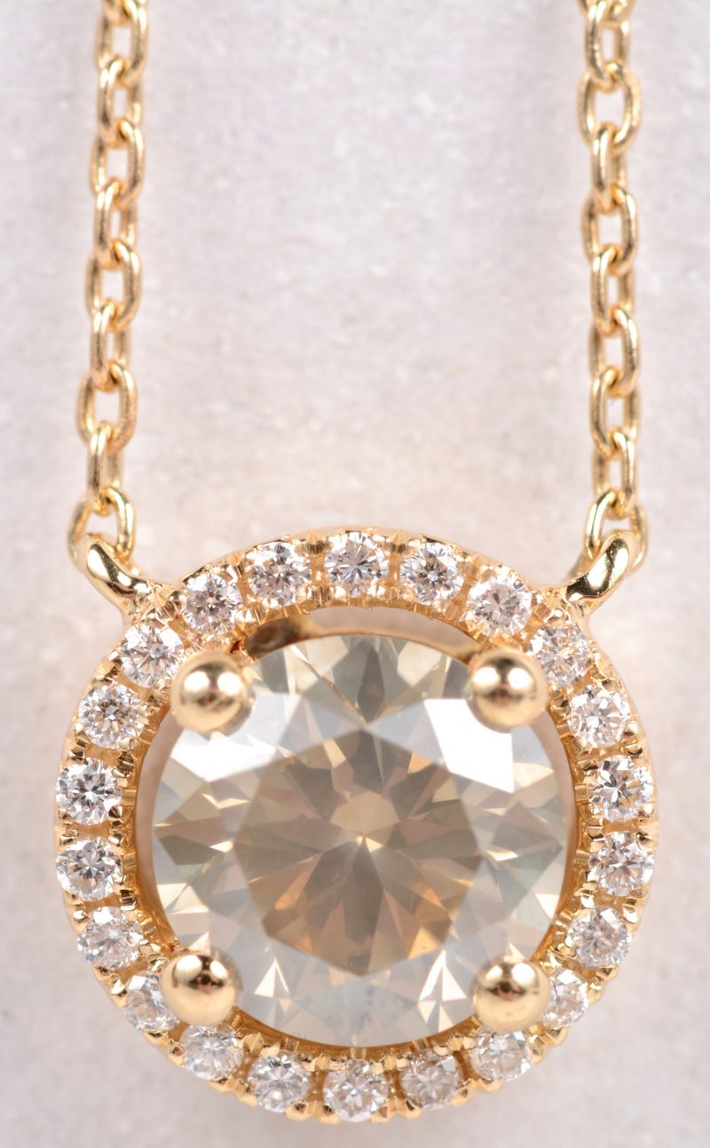 Een 18 karaats geel gouden ketting met hanger bezet met een centrale diamant van ± 1,11 ct. en briljanten met een gezamenlijk gewicht van ± 0,13 ct.