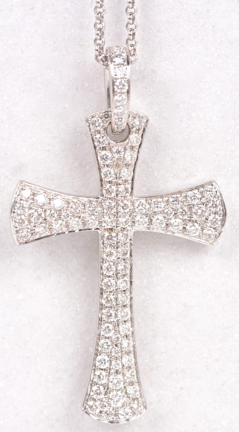 Een 18 karaats wit gouden ketting met hanger in de vorm van een kruisje bezet met diamanten met een gezamenlijk gewicht van ± 0,48 ct.