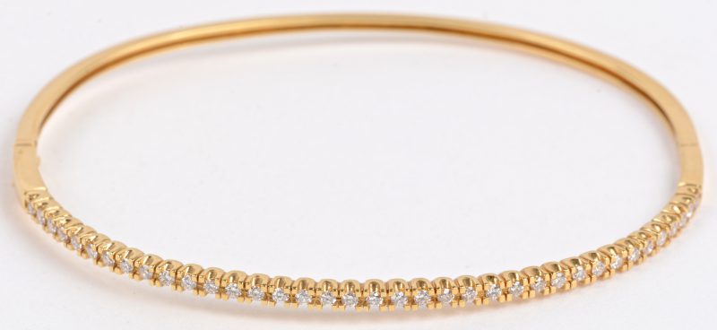Een 18 karaats geel gouden slavenarmband bezet met diamanten met een gezamenlijk gewicht van ± 0,58 ct.