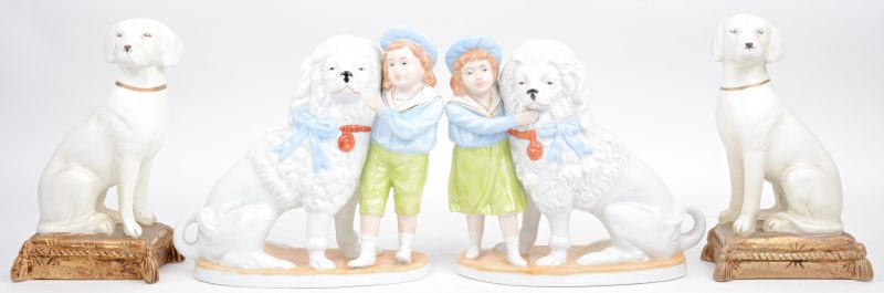 Twee boeksteunen in de vorm van zittende honden en twee groepjes van polychroom porselein met poedels en jongetjes.