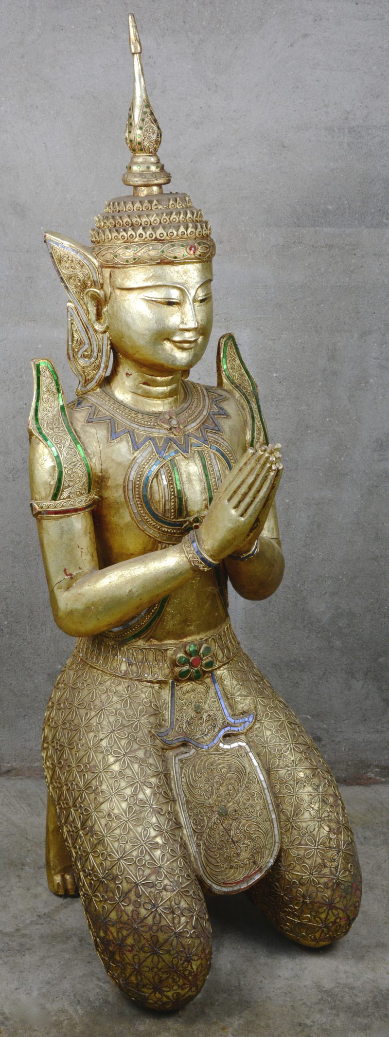 Een knielende Thaise Boeddha van verguld en gepolychromeerd hout.