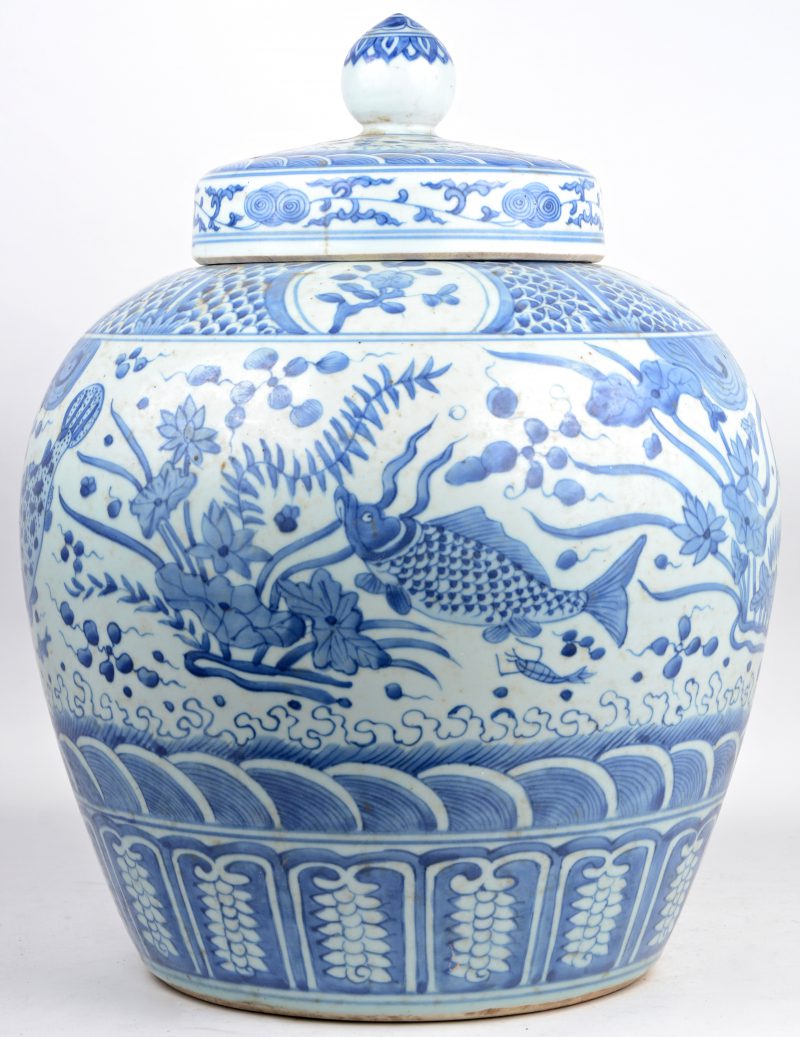 Een grote bolle dekselvaas van Chinees porselein, versierd met een blauw op wit decor van karpers.