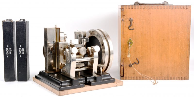 Een laat XIXe eeuwse verticale precisiesnijmachine van staal en gietijzer. In houten kist.