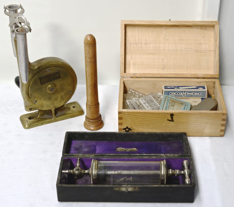 Een lot XIXe eeuwse manuele laboratoriumcentrifuge, een testbuis in houten beschermer en een set oude naalden en spuiten.