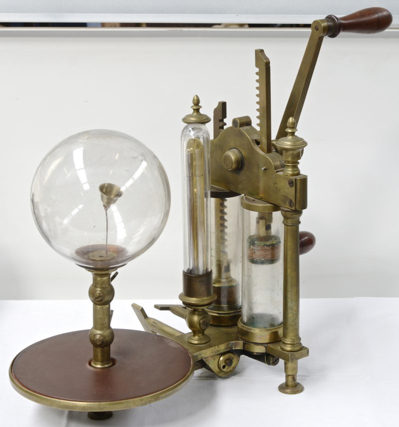 Een XIXe eeuwse manuele vacuümpomp van messing en glas.