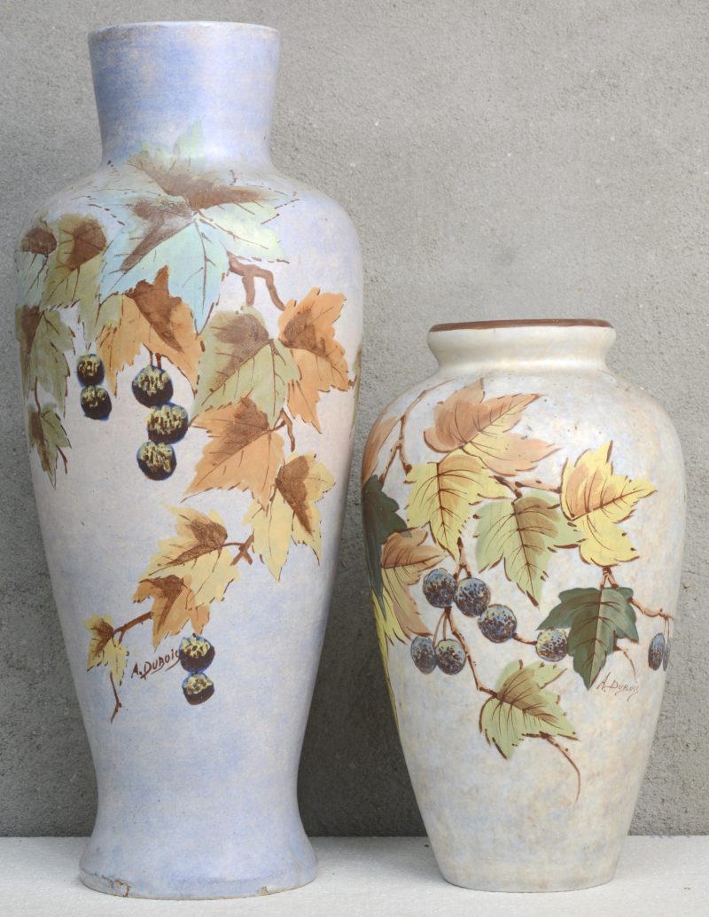 Twee vazen van Bergens aardewerk met meerkleurige bladerdecors. Beide gesigneer ‘A. Dubois’. De grootste met kleine schilfer onderaan.