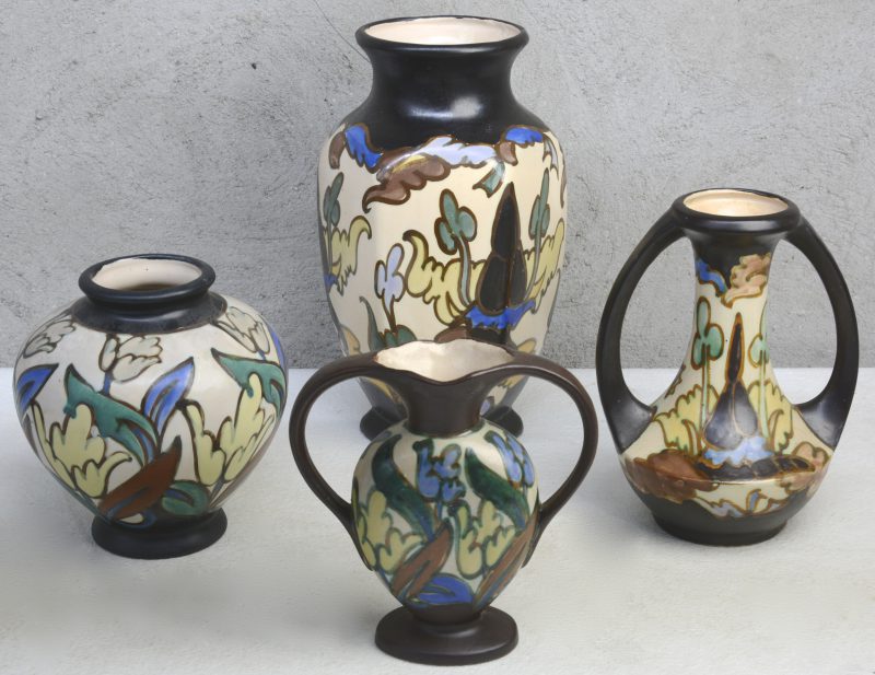 Een lot van vier verschillende vazen van meerkleurig aardewerk in de stijl van Gouda. Onderaan gemerkt.