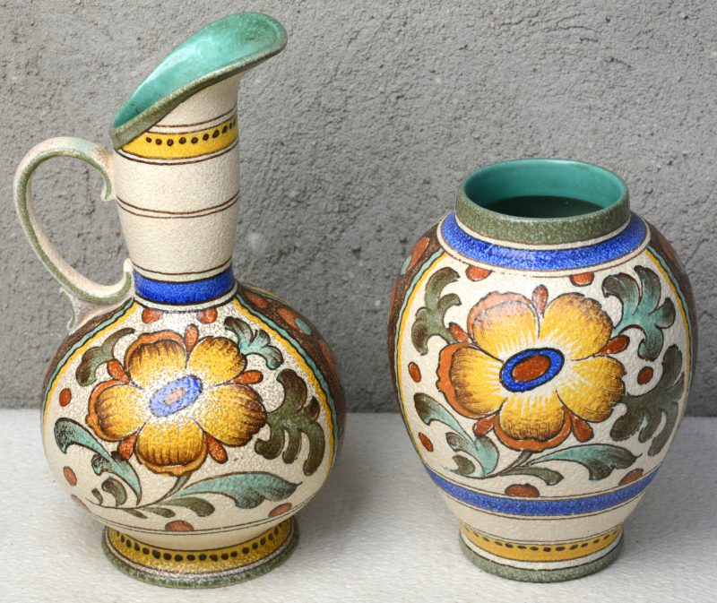 Een schenkkan en een vaas van meerkleurig Gouds plateel, versierd met decor ‘Charmi’. Onderaan gemerkt.