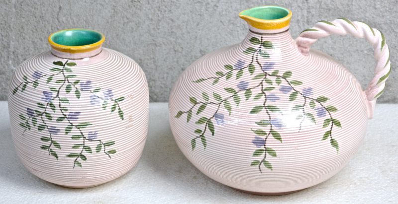 Een kruik en een vaas van meerkleurig aardewerk met een decor van bloeiende takken, ‘Unia’. Onderaan gemerkt.