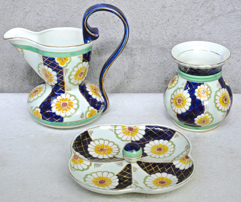 Een schenkkan, een vaas en een aperitefschotel van meerkleurig aardewerk, versierd met decor ‘Sinia’.