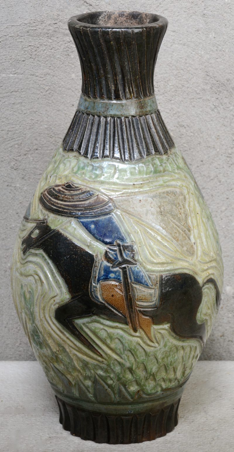 Een grote vaas van meerkleurig geglazuurd steengoed met een decor van steekspelende ruiters. Onderaan gemerkt. restauratie aan de hals.