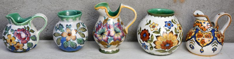 Een lot Gouds aardewerk met glanzend glazuur, bestaande uit een bolle vaas, drie kannetjes en een kleiner bol vaasje. Decors ‘Ata’, ‘Frato’, ‘Mara’, & ‘Plonia’. Allen gemerkt. Gaaf.
