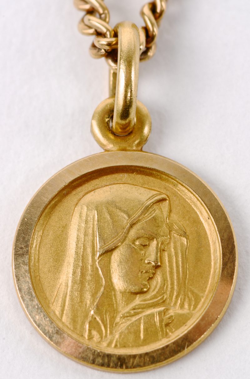 Een 18 karaats geel gouden ketting met hanger met afbeelding van Moeder Maria.