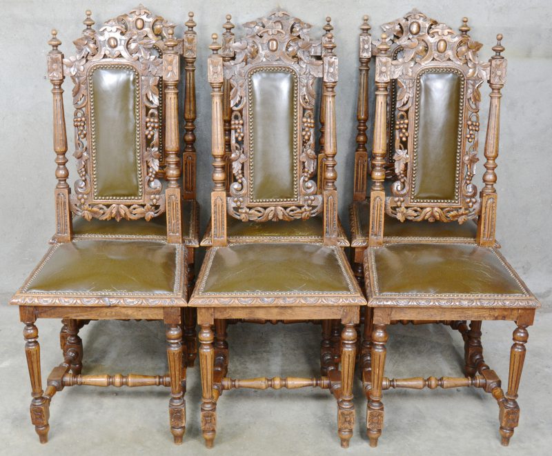 Een reeks van zes gebeeldhouwd eikenhouten stoelen in renaissancestijl met lederen zit.