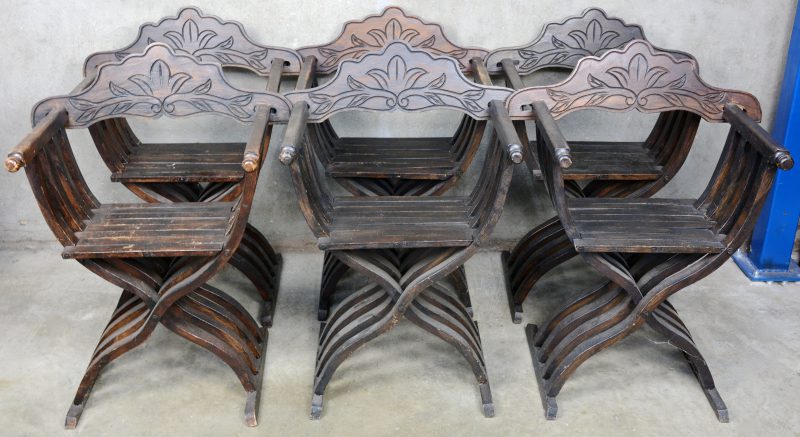 Een reeks van zes houten faldistoria met gebeeldhouwde rug.
