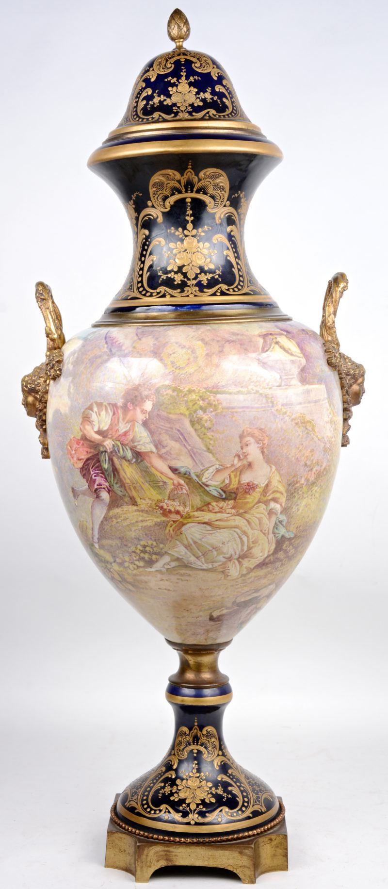 Een vaas van kobaltblauw aardewerk, versierd met een handgeschilderd meerkleurig decor en met bronsbeslag. In de stijl van het Sèvresporselein.