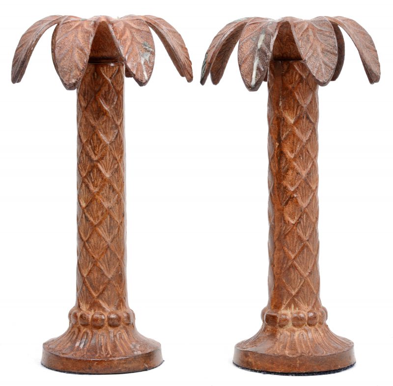 Een paar bronzen kandelaars in de vorm van palmbomen.