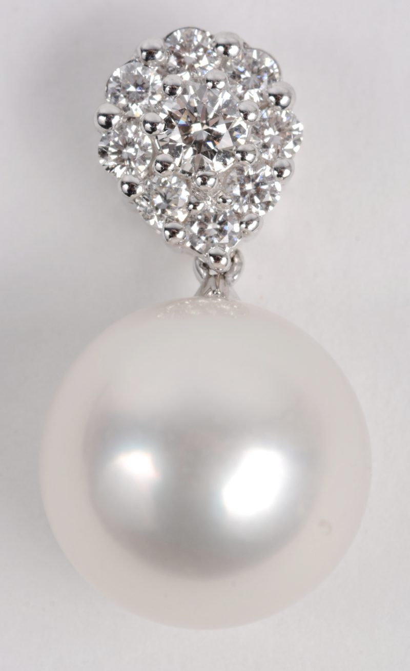 Een 18 karaats wit gouden hanger bezet met diamanten met een gezamenlijk gewicht ± 0,30 ct. en een parel. Met certificaat.