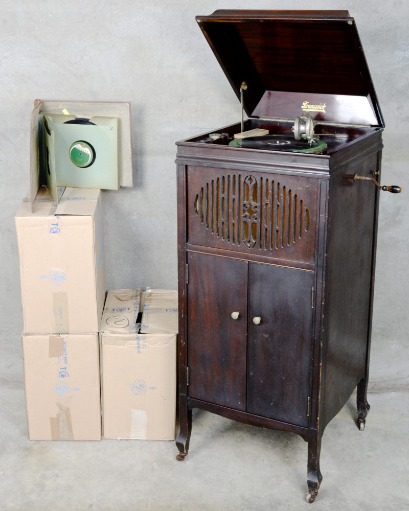 Een grammofoonmeubel met een groot aantal platen.