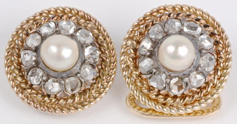 Een paar 14 karaats geel gouden oorbellen bezet met diamanten oude slijp  met een gezamenlijk gewicht van ± 1 ct. en twee parels.