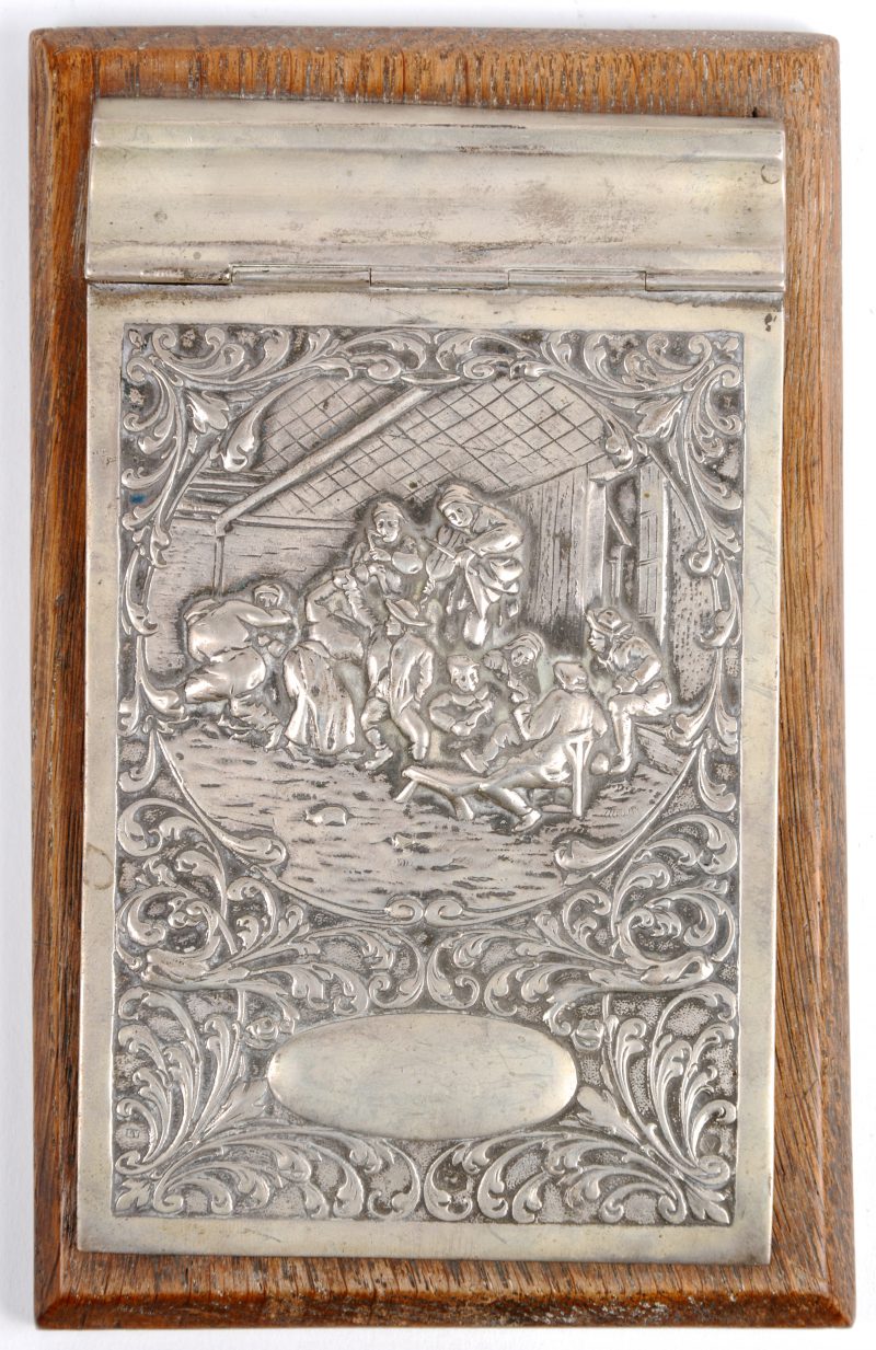 Een zilveren bas relief met de voorstelling van muziekkanten in een herberg.