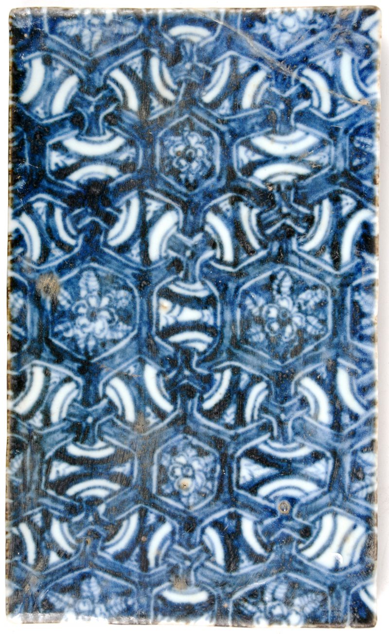 Een tegel van Chinees porselein, versierd met blauwe motieven. Restauratie.