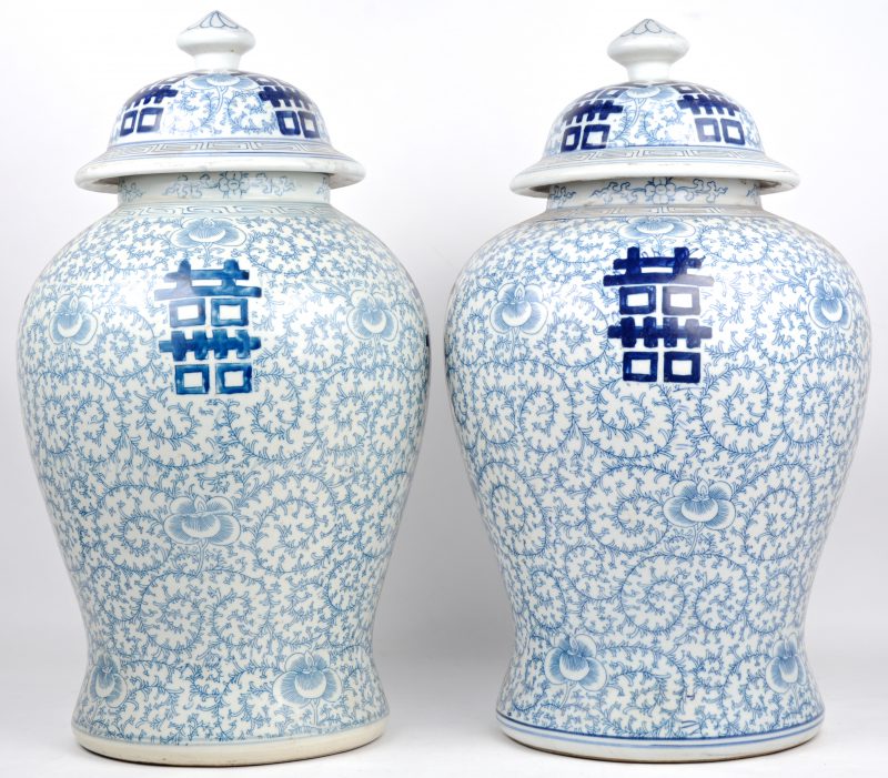 Een paar dekselvazen van Chinees porselein, versierd met een blauw op wit decor van florale motieven en langlevenstekens.