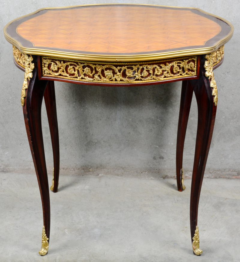 Een gefineerd houten tafel in Lodewijk XV-stijl, versierd met verguld bronsbeslag en met parketwerk.