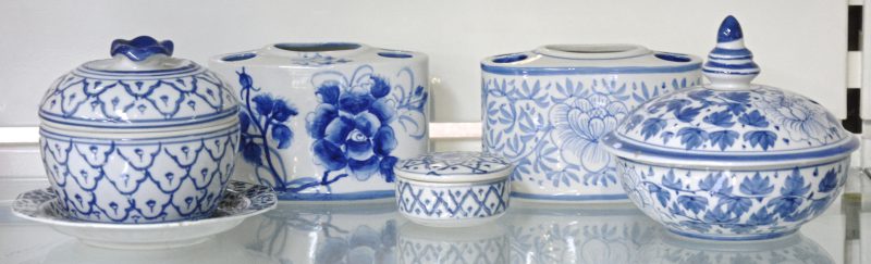 Een lot blauw en wit porselein, bestaande uit twee bloemenvaasjes, drie dekselpotjes en een schaaltje.